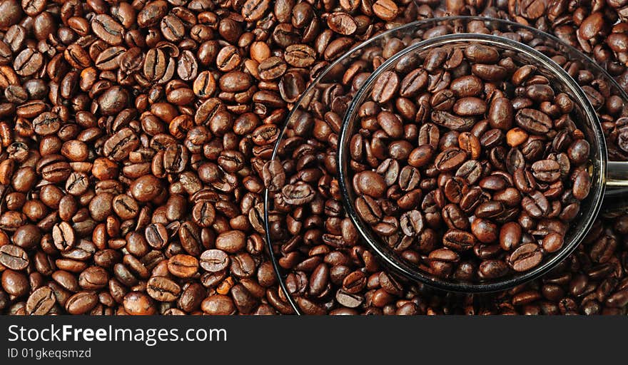 There are outlines of cup and saucer in-bulk coffee grains as background. There are outlines of cup and saucer in-bulk coffee grains as background