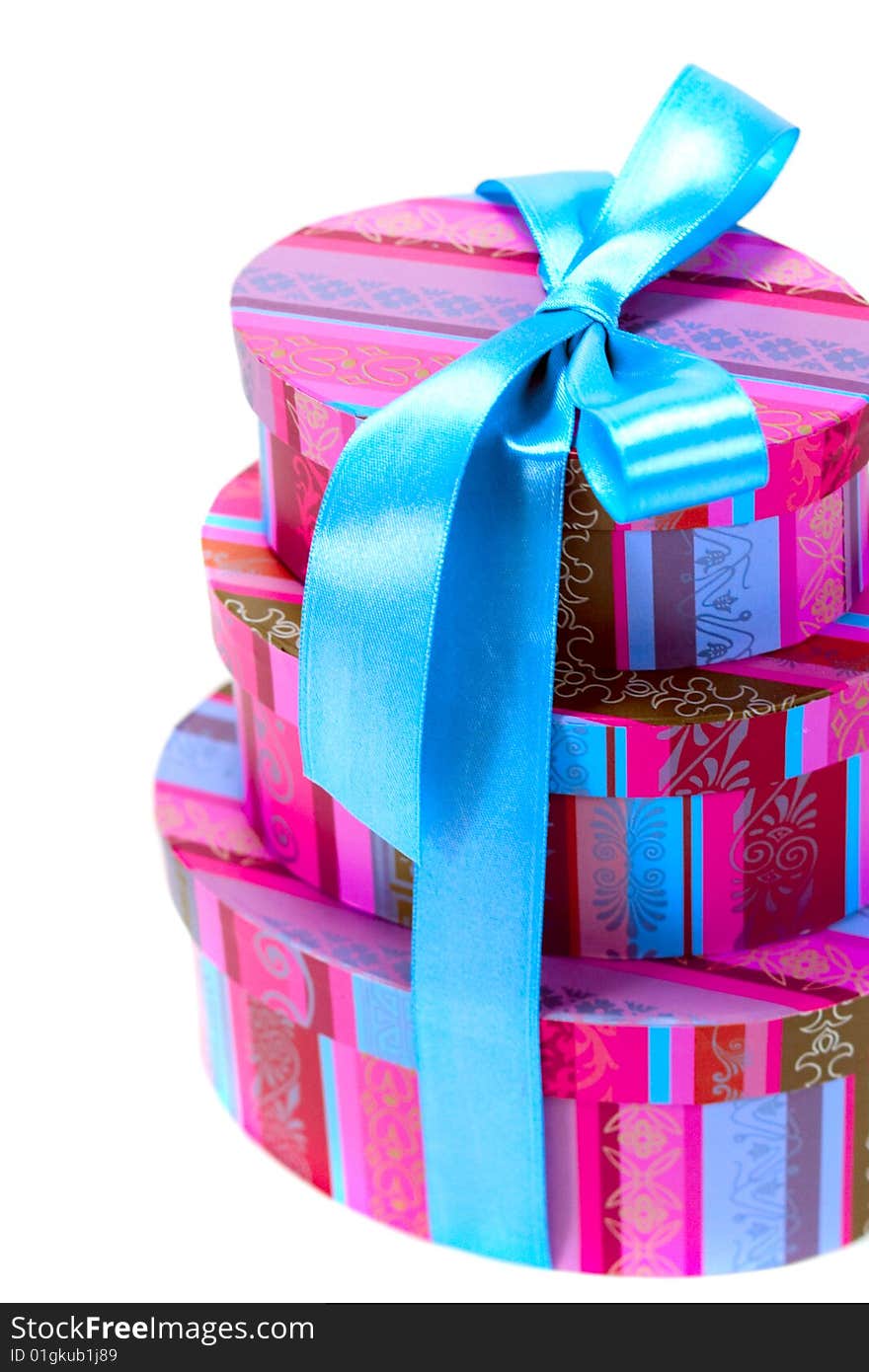 Pyramid of colorfull gift boxes with blue bow closeup on white background