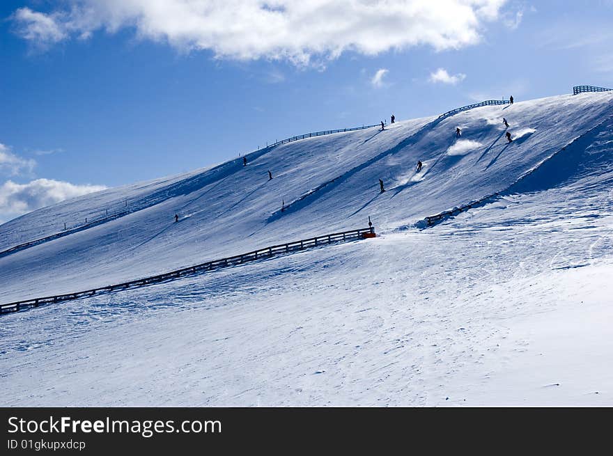 Snow covered mountain with few skiers on it