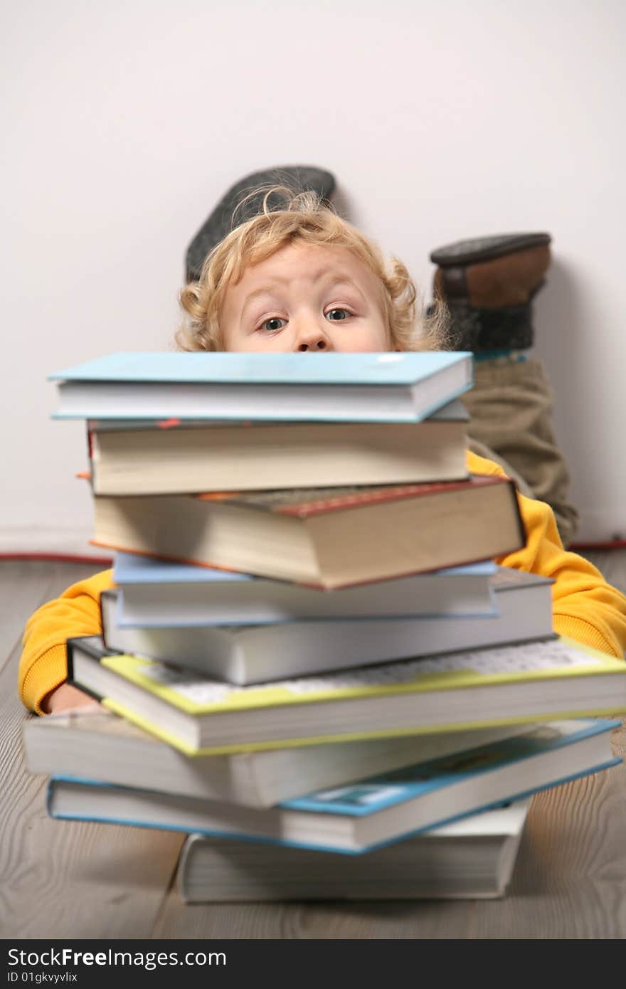 Boy is hiding behind books. Boy is hiding behind books.