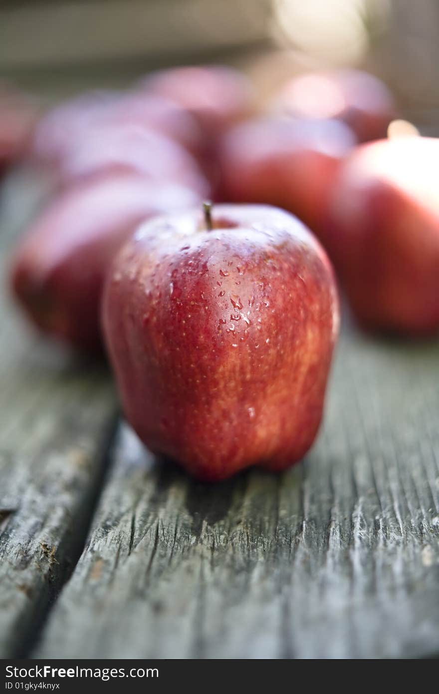 Apples sprayed with water placed on an old wood tabletop. Apples sprayed with water placed on an old wood tabletop.