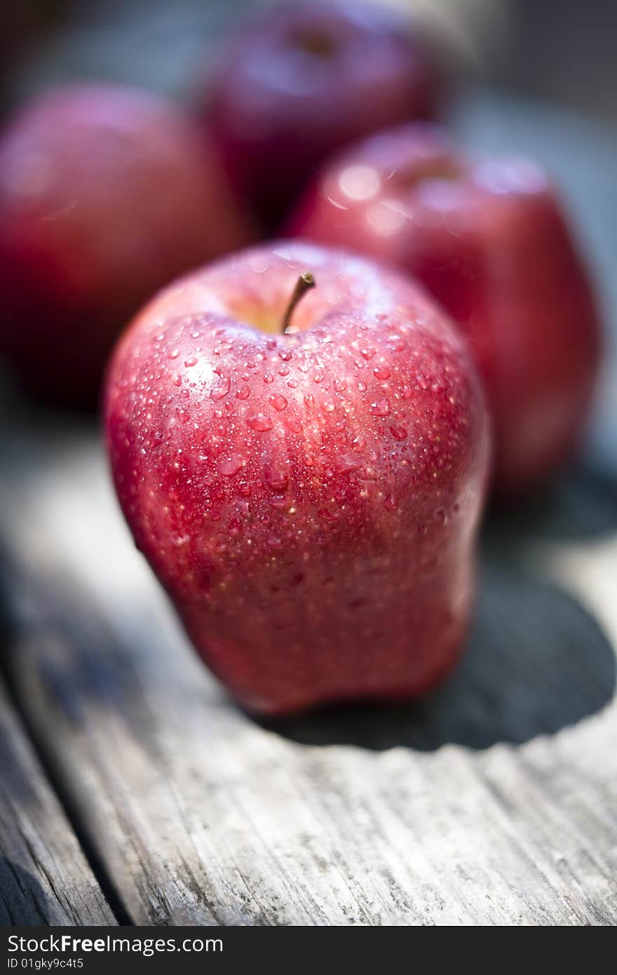 Apples sprayed with water placed on an old wood tabletop. Apples sprayed with water placed on an old wood tabletop.