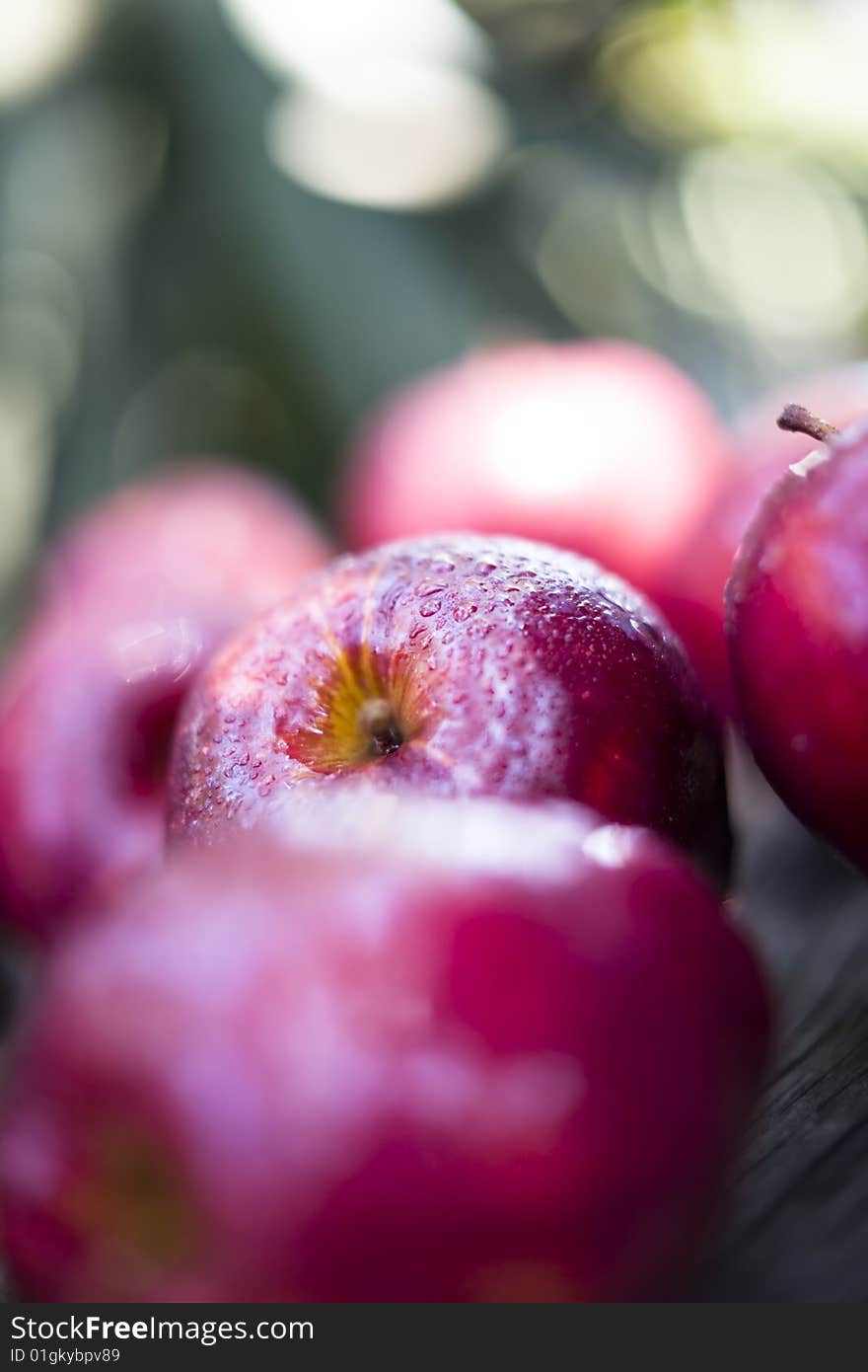 Apples sprayed with water placed on an old wood tabletop. Apples sprayed with water placed on an old wood tabletop.