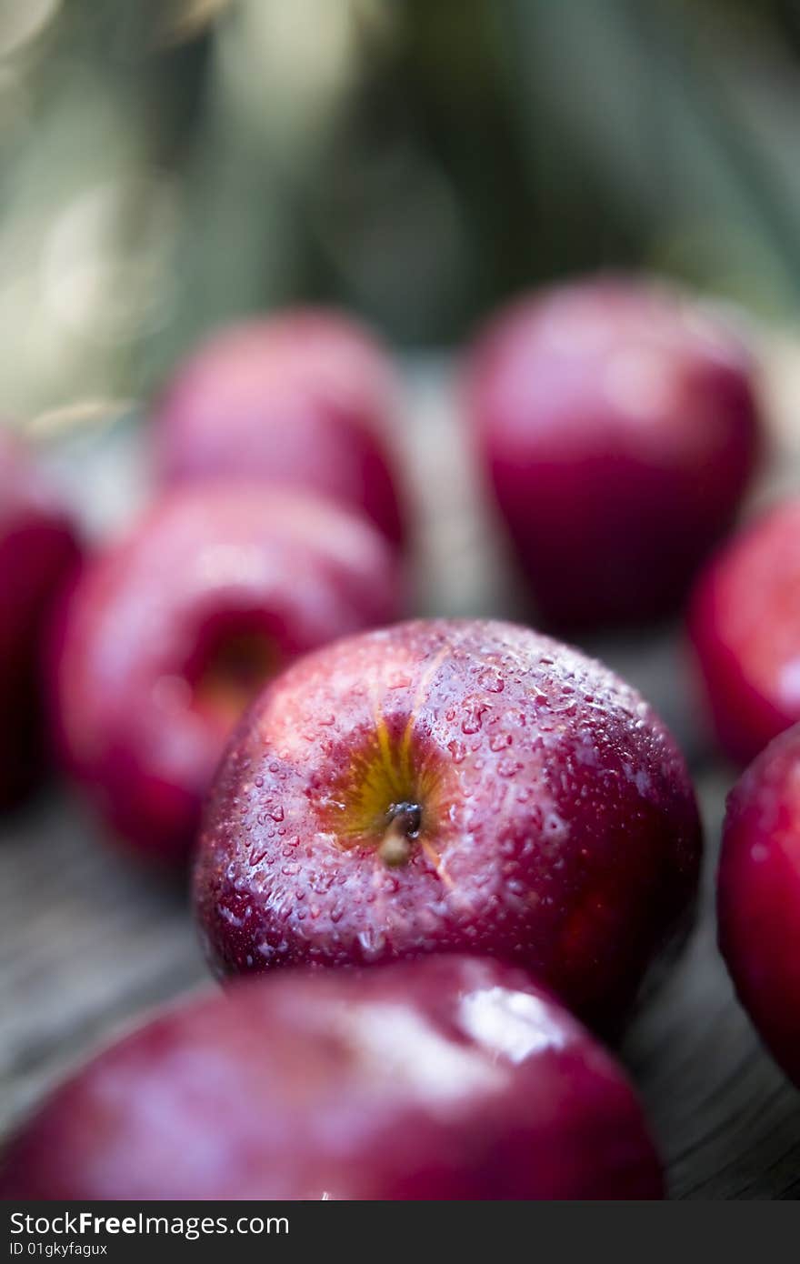 Apples sprayed with water placed on an old wood tabletop. Apples sprayed with water placed on an old wood tabletop.