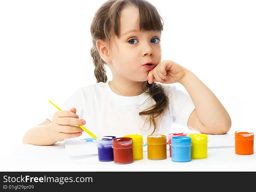 Cute little girl sitting by the table and painting with watercolor. Cute little girl sitting by the table and painting with watercolor