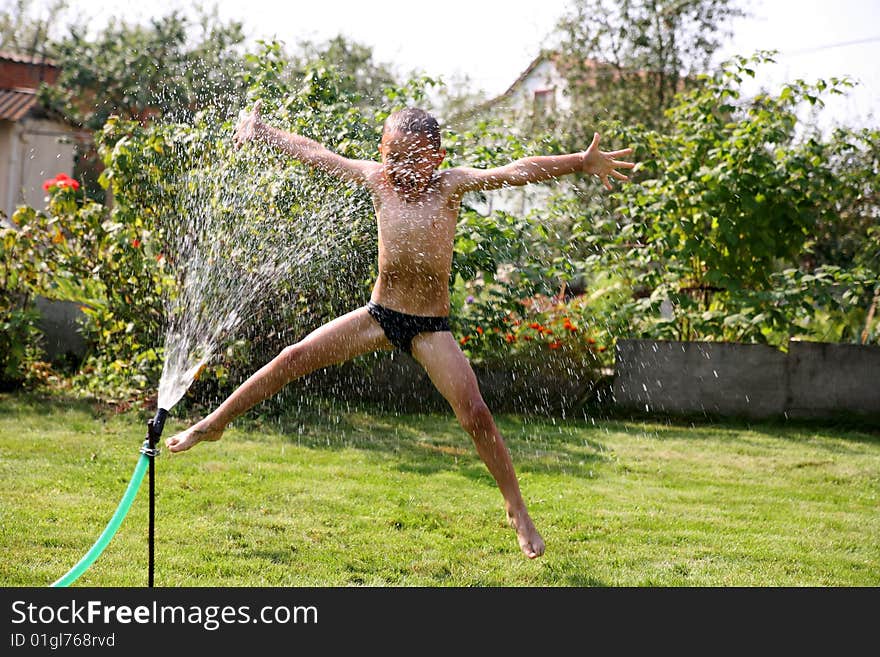 Jumping boy under summer shower