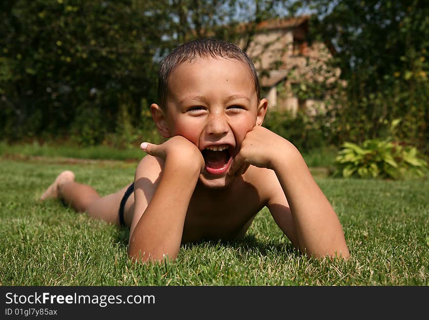 Little boy laughting in green grass. Little boy laughting in green grass