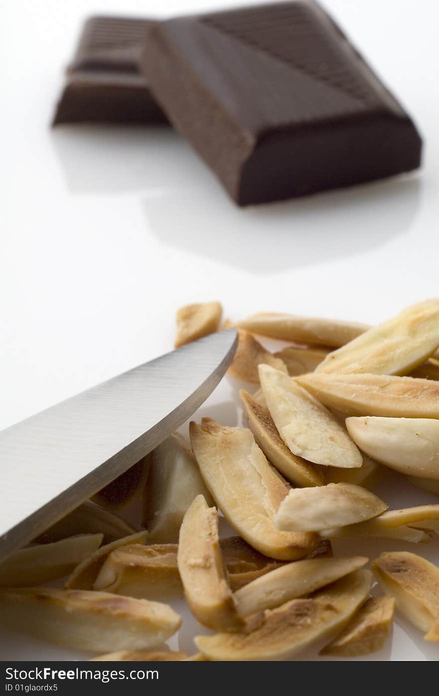 Knife and split roasted almonds with chocolate