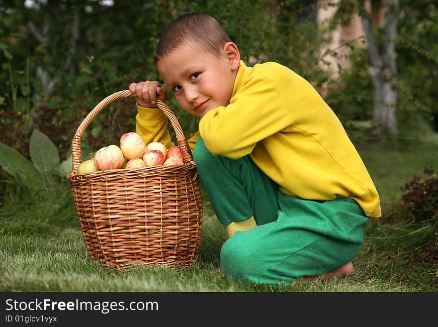 Little boy with apples outdoors