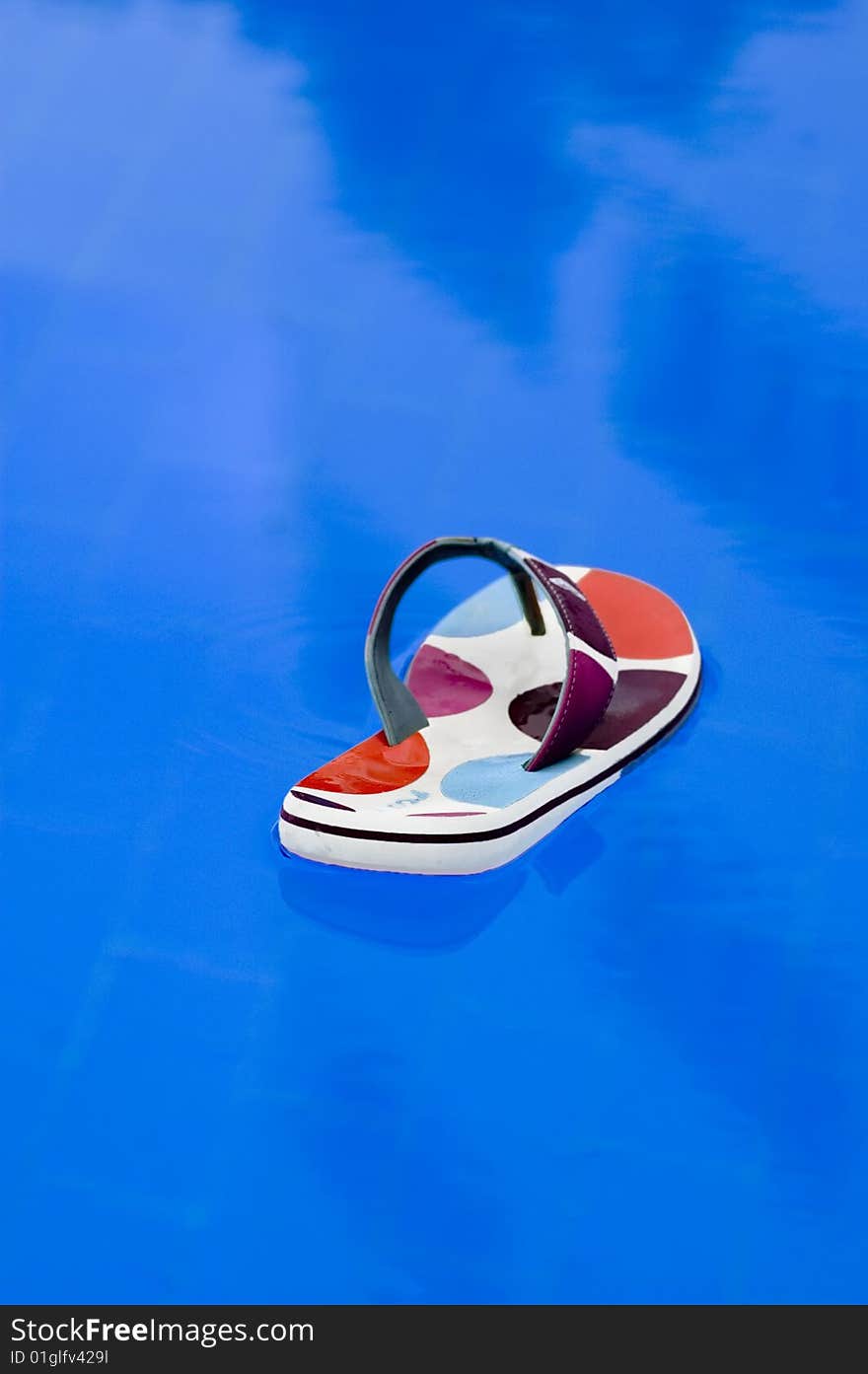 Colorful beach shoe floating around in a pool