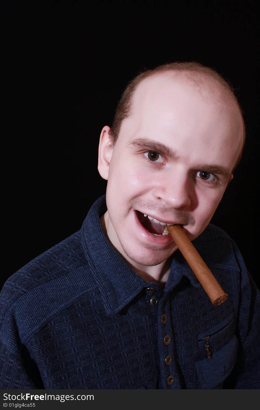 Young man with cigar on black background