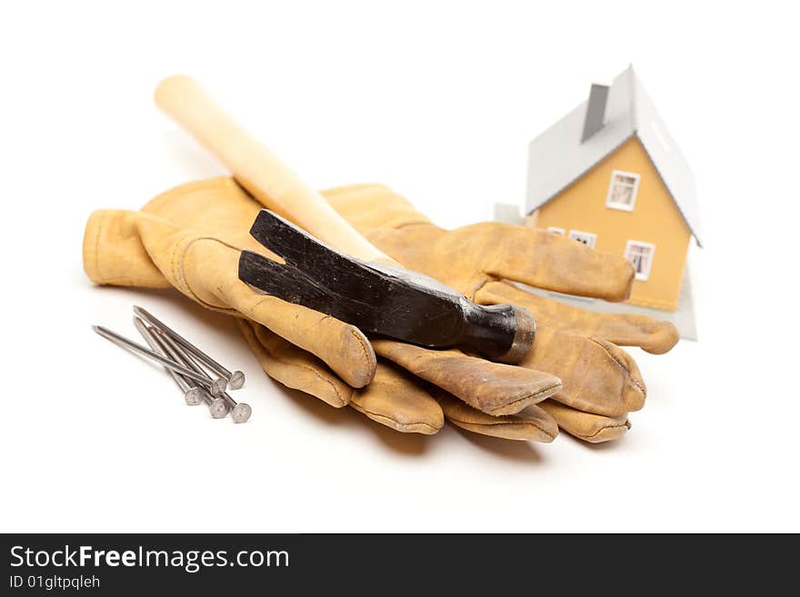 Hammer, Gloves, Nails and House Isolated on a White Background.