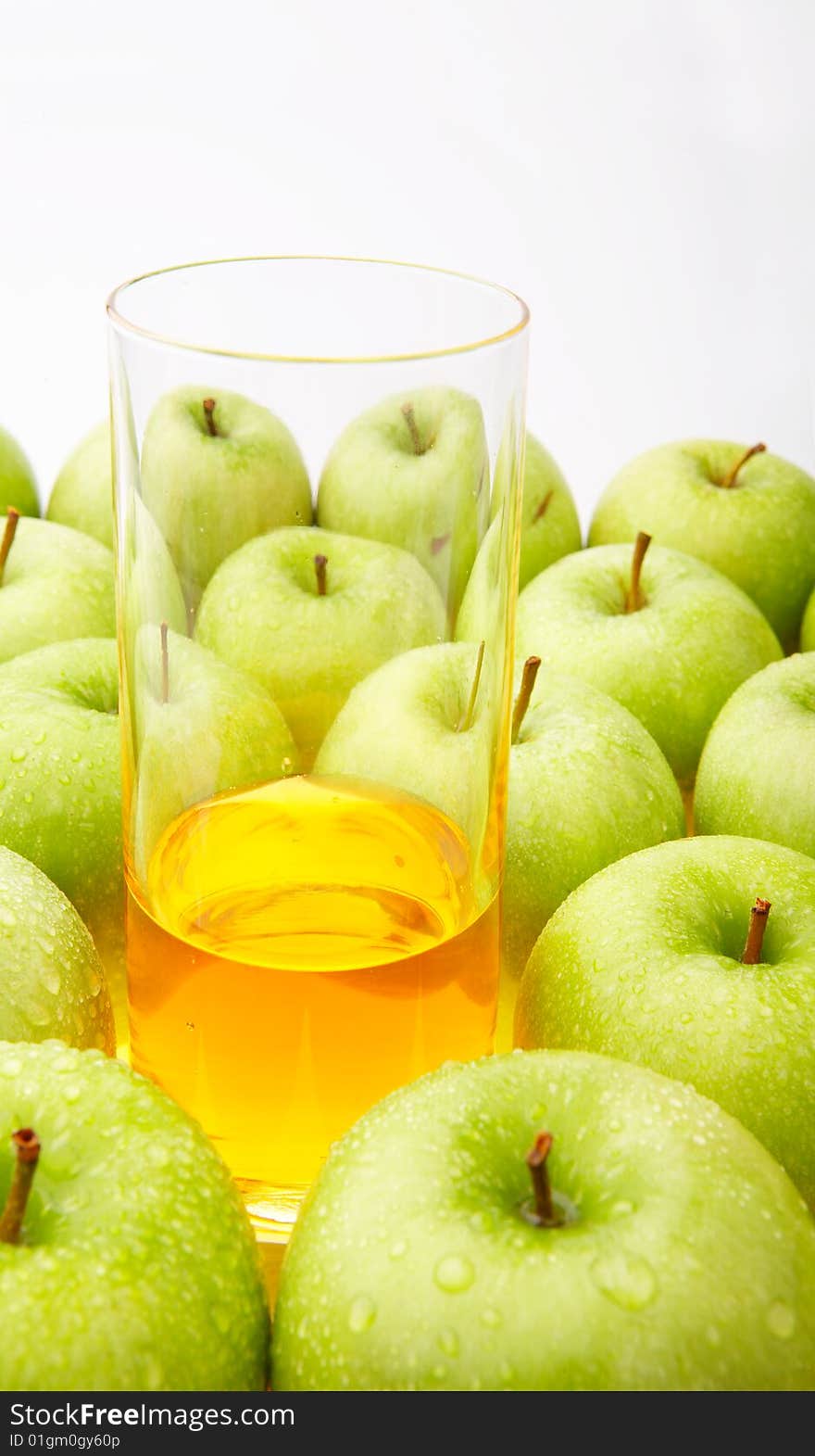 Apple juice in a glass among apples