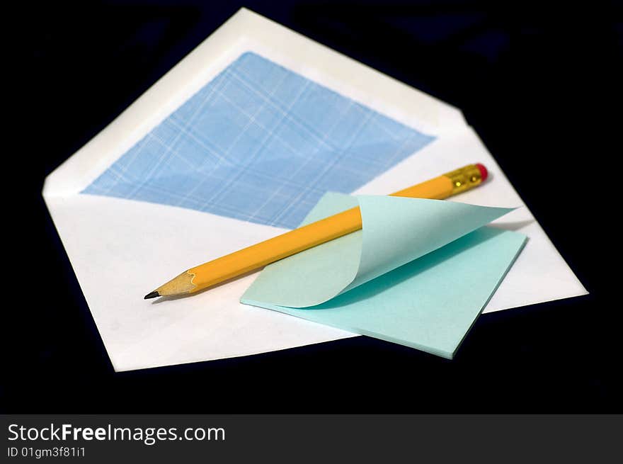 Pencil and note against the black background. Pencil and note against the black background