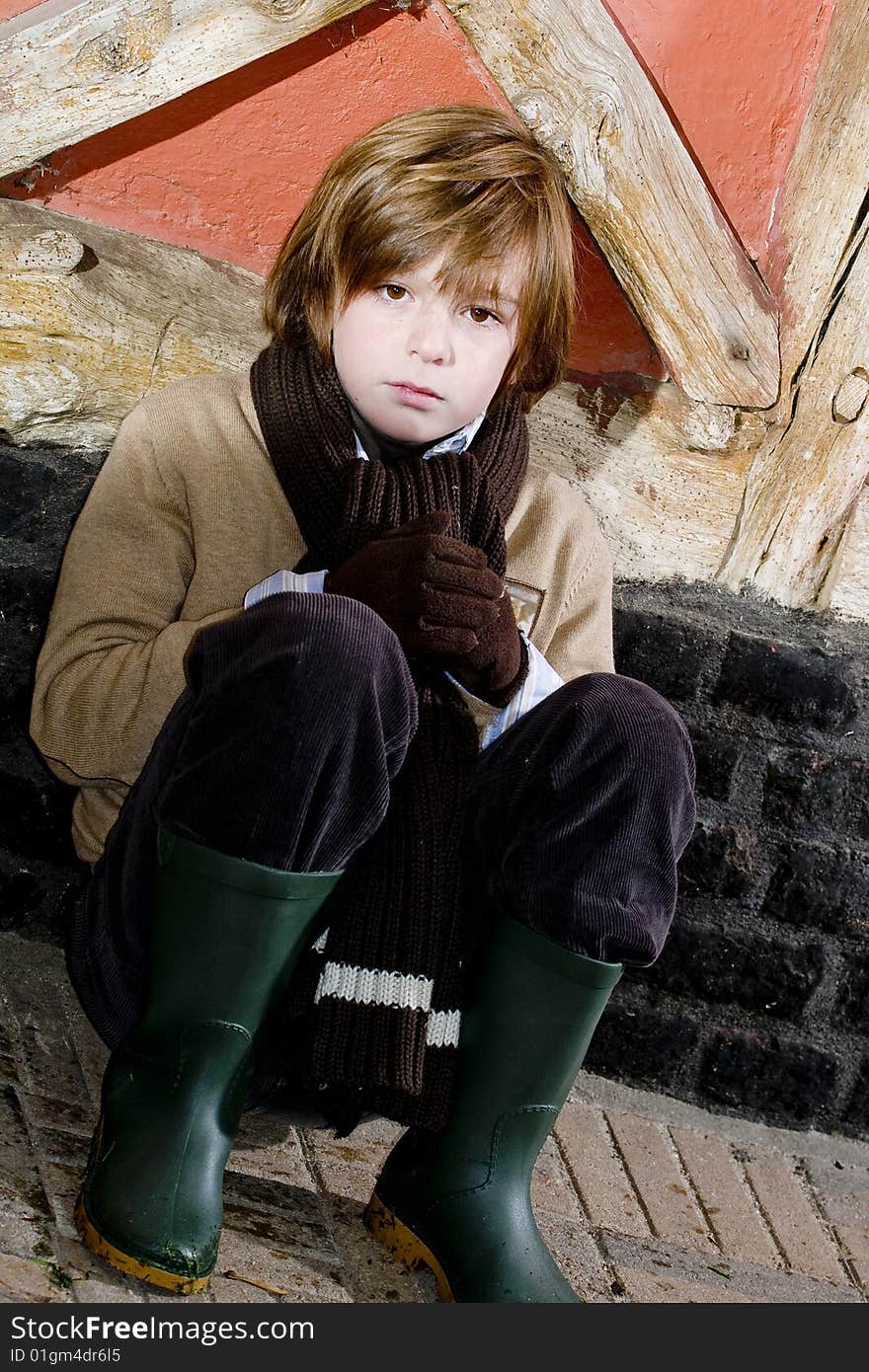 Cute young autumn boy standing near cottage. Cute young autumn boy standing near cottage