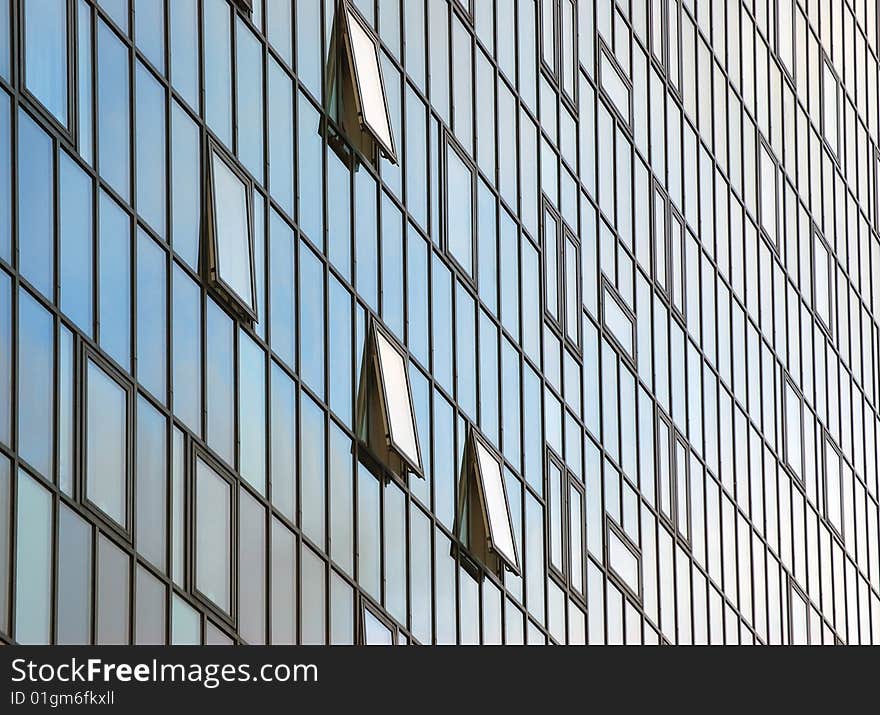 Close-up of glass fronted office block in city