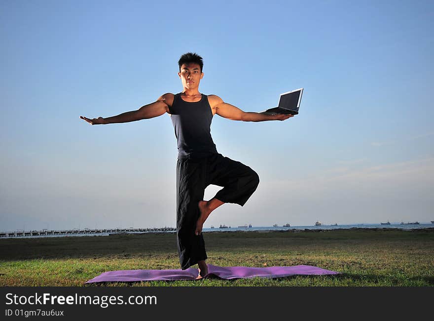 Picture of man doing yoga by the beach.