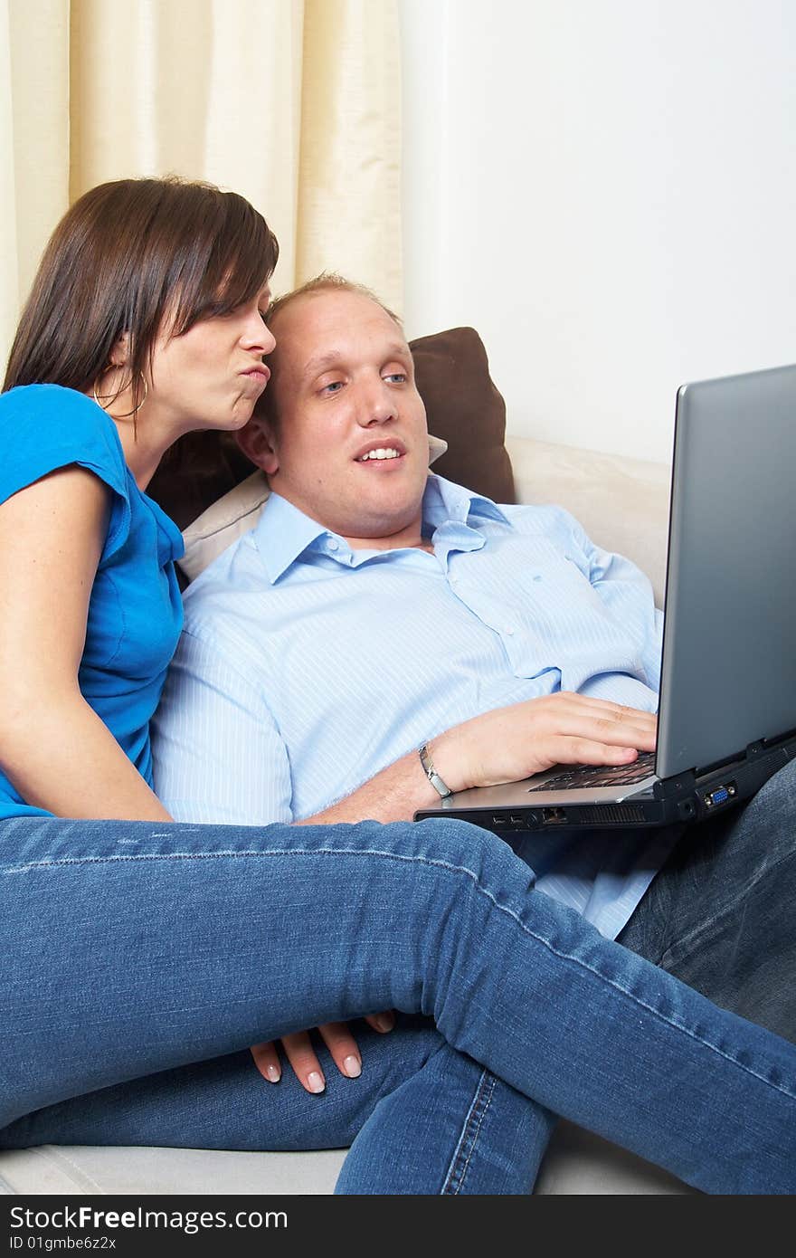 Young couple on the couch at home looking at the laptop!. Young couple on the couch at home looking at the laptop!