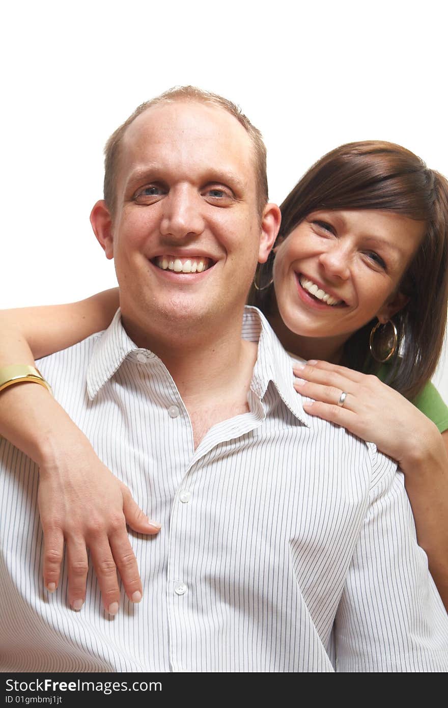 A young couple in love. The woman hugs the man from behind. Isolated over white. A young couple in love. The woman hugs the man from behind. Isolated over white.