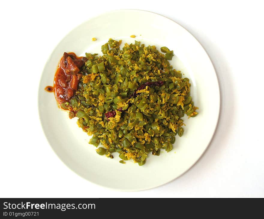 Indian Spicy French Beans Vegetable Dish with Red Mango Pickle in a Round Plate on White Background. Indian Spicy French Beans Vegetable Dish with Red Mango Pickle in a Round Plate on White Background