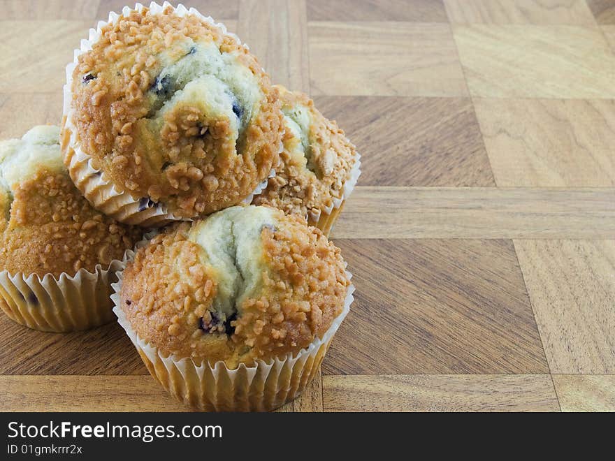 Several blueberry muffins on a wooden texture