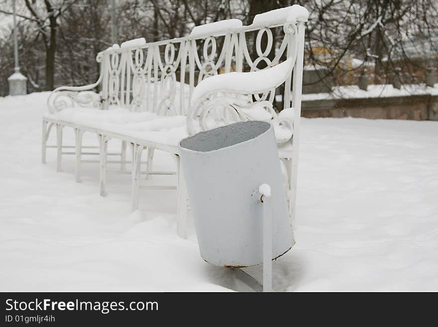 Urn for dust against a white snow-covered bench