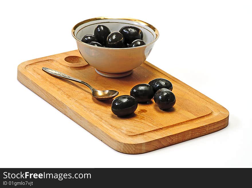 Olive in white cup on wooden plate