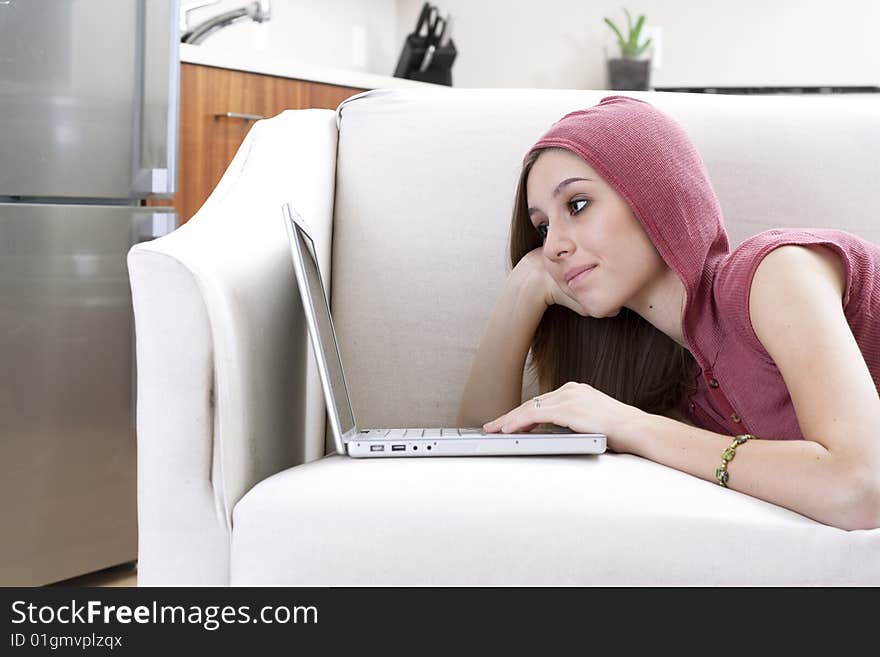 A young woman using a laptop in a modern home. A young woman using a laptop in a modern home.