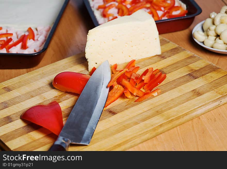 Stock photo: an image of food in the kitchen: mushrooms, cheese, paprika and knife. Stock photo: an image of food in the kitchen: mushrooms, cheese, paprika and knife