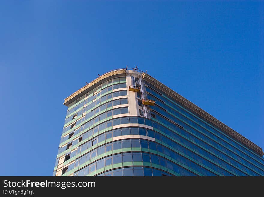 Finishing works on building construction on blue sky