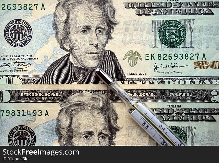 The thermometer on a background of a 20-dollar banknotes. The thermometer on a background of a 20-dollar banknotes