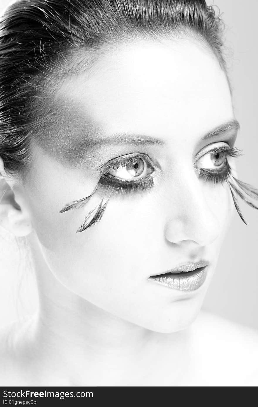 Attractive young lady with extravegant makeup and eyelashes in black and white