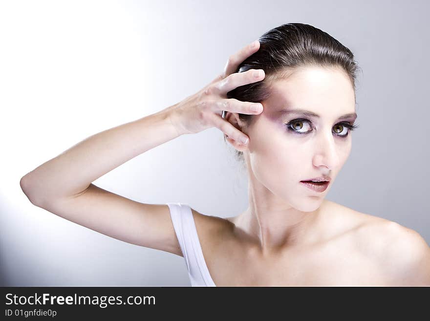 Attractive young lady with extravegant makeup and black eyelashes black and white background with some gray