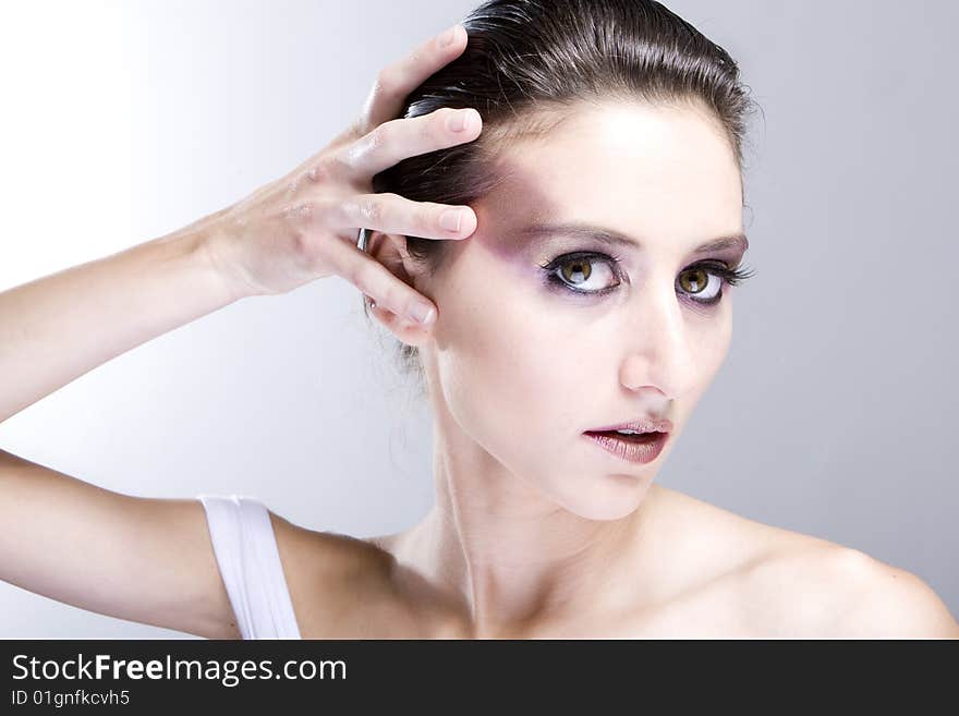 Attractive young lady with extravegant makeup and black eyelashes black and white background with some gray