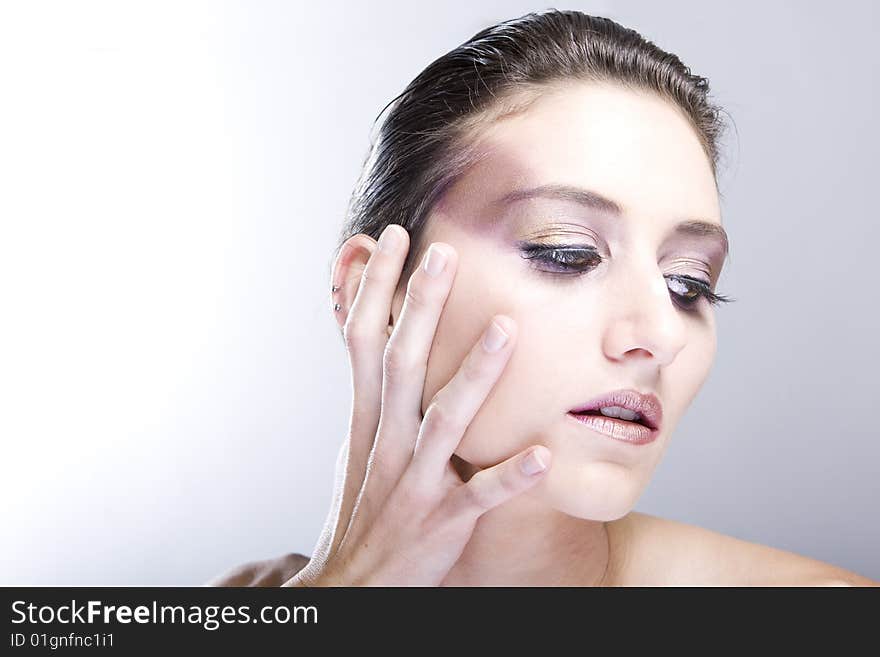 Attractive young lady with extravegant makeup and black eyelashes black and white background with some gray