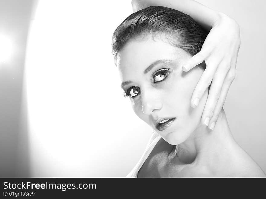 Attractive young lady with extravegant makeup and black eyelashes black and white background with some gray