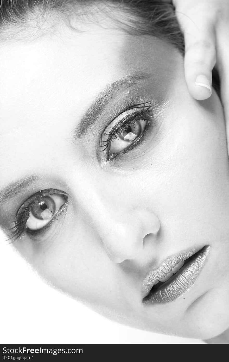 Attractive young lady with extravegant makeup and black eyelashes black and white background with some gray