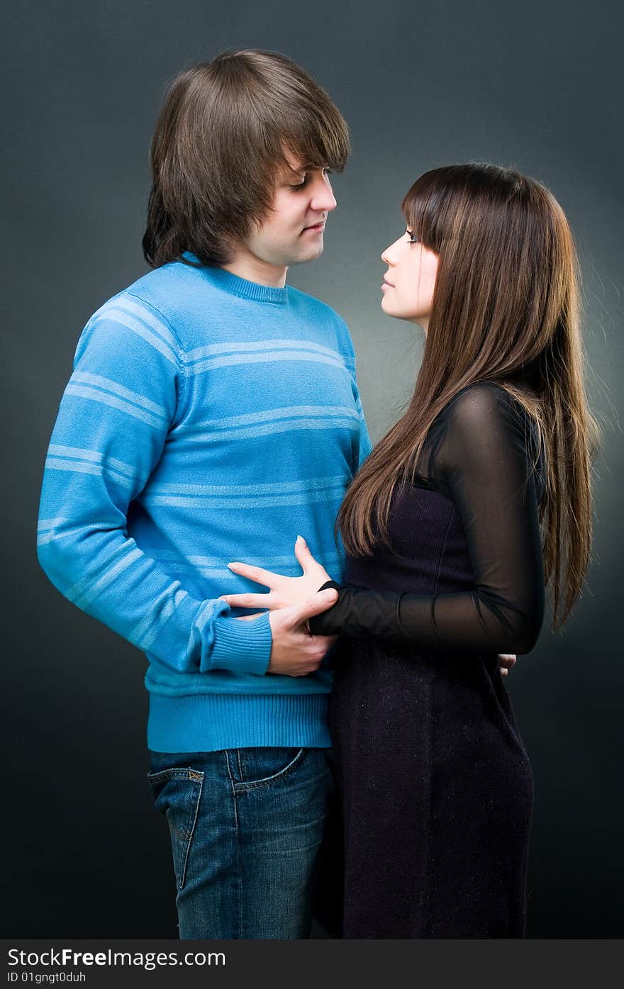 Young couple embracing, studio shot