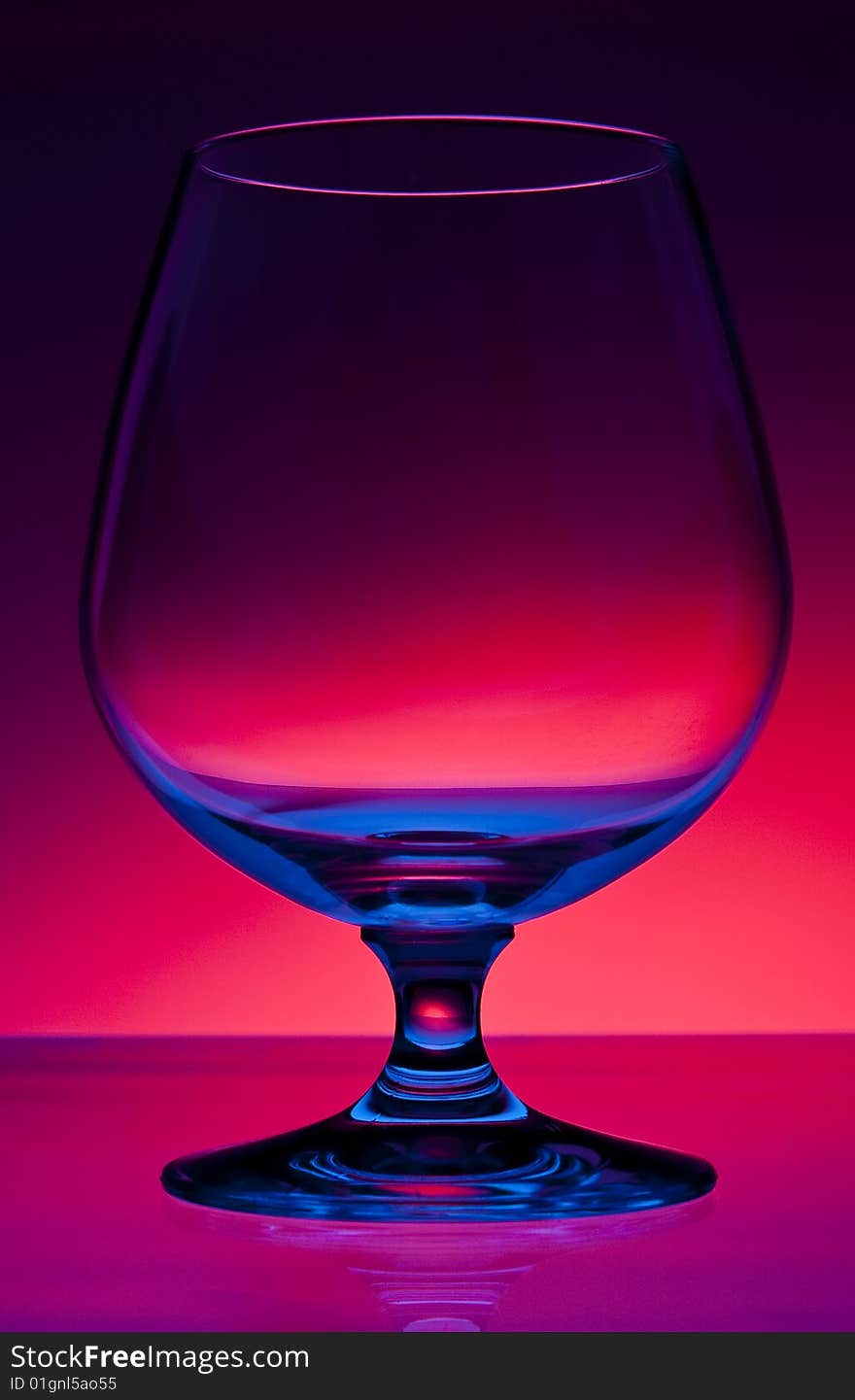 Empty hard drink glass on dark red gradient background. Empty hard drink glass on dark red gradient background