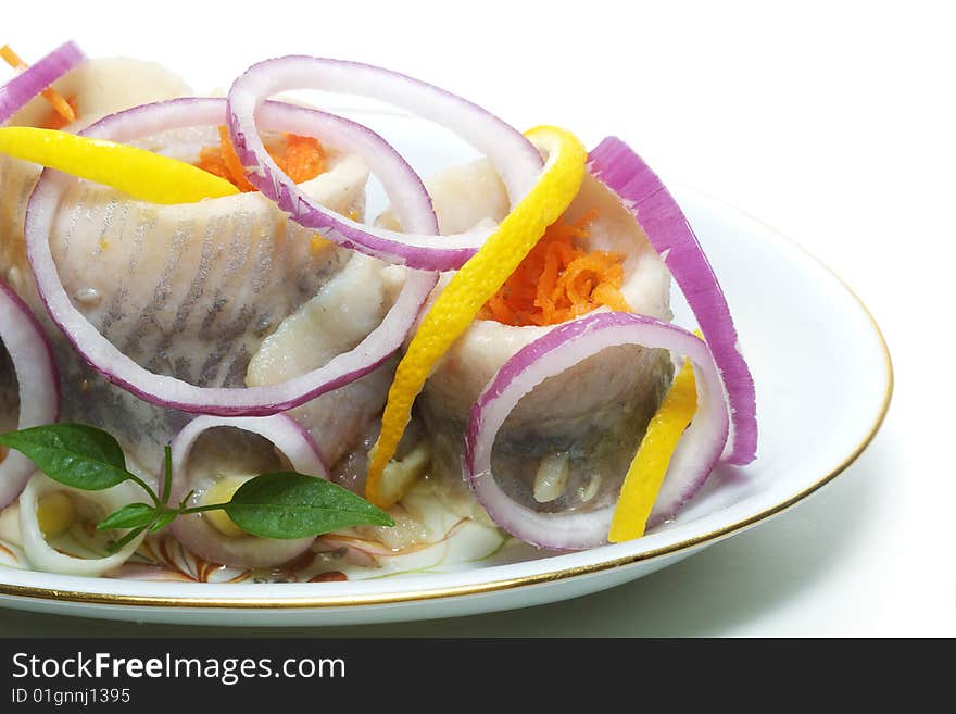 Herrings with vegetables on the plate isolated. Herrings with vegetables on the plate isolated