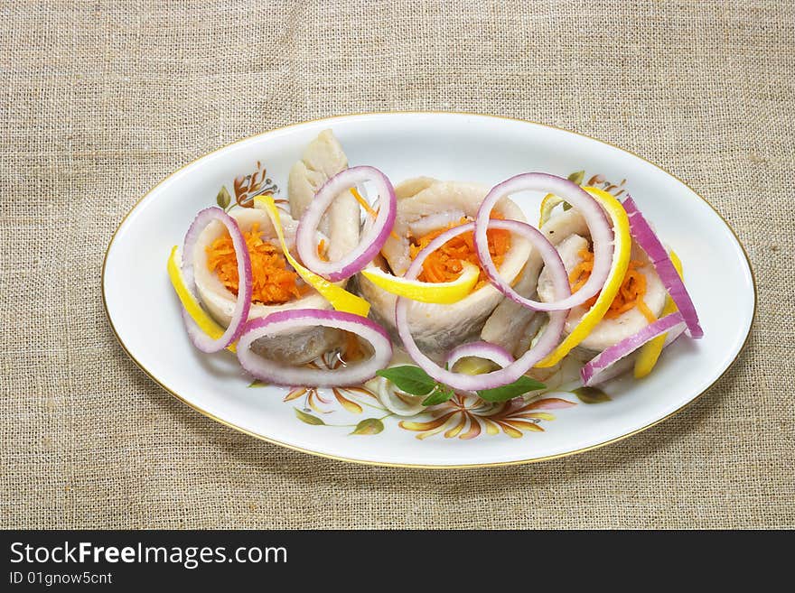 Herrings with vegetables on the plate. Herrings with vegetables on the plate