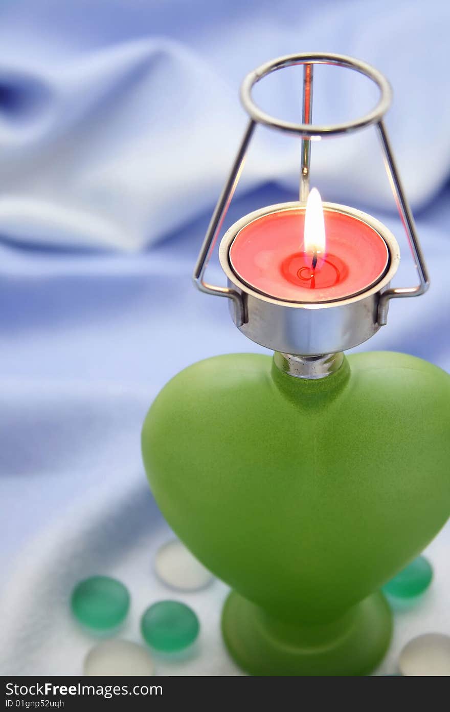 Green heart candlestick with  flaming candle. Green heart candlestick with  flaming candle