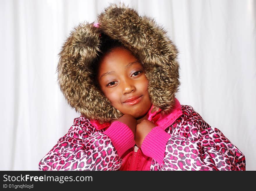 Girl posing in a winter coat with furry hood.