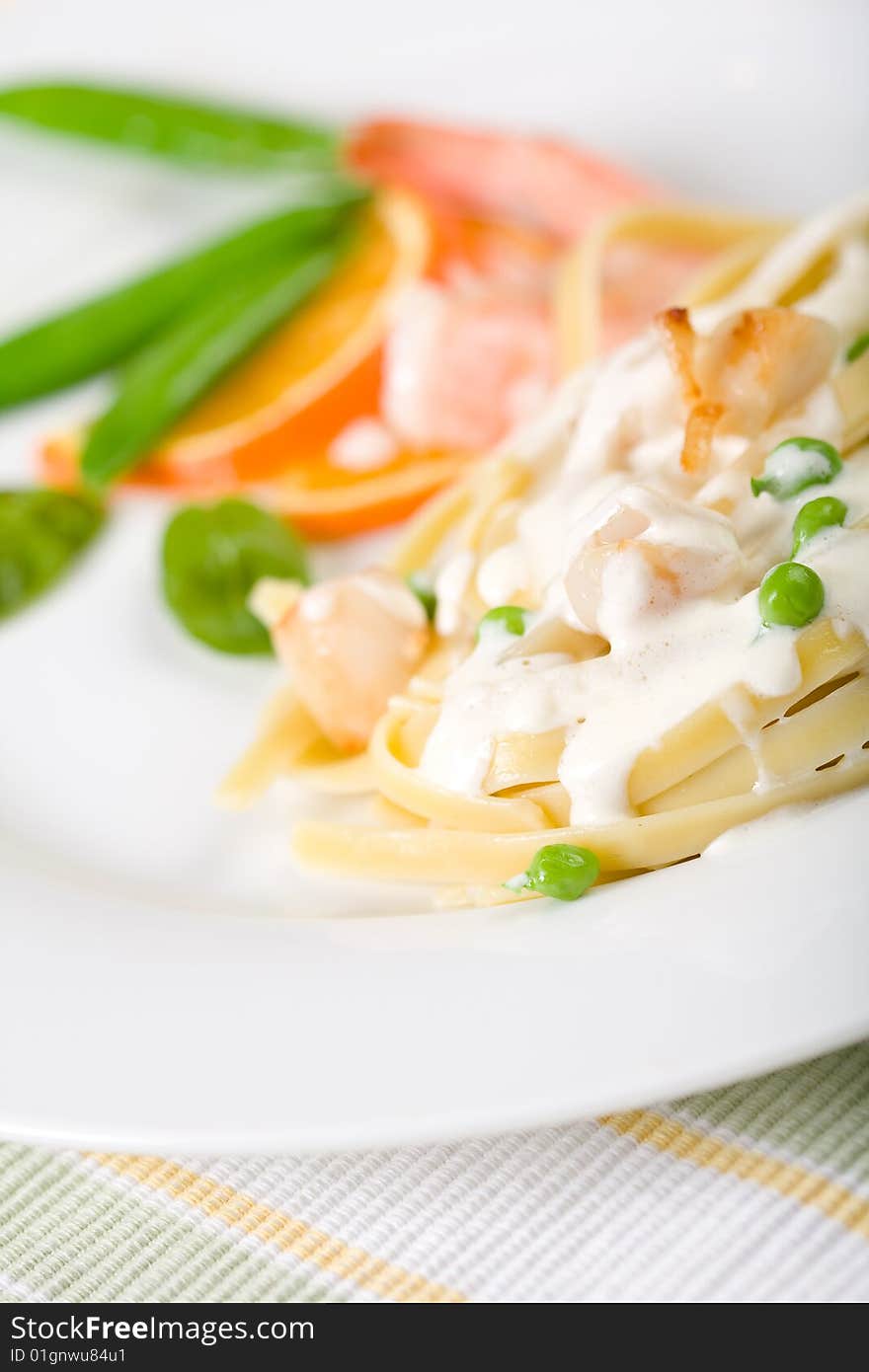 Pasta with Peas, shrimp, and scallops on a white plate. Pasta with Peas, shrimp, and scallops on a white plate