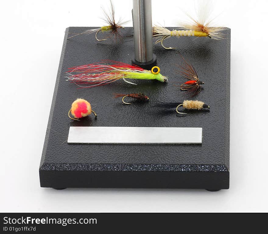 Assorted flies for fly fishing on fly tying base. Assorted flies for fly fishing on fly tying base