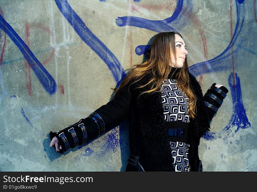 Stock photo: an image of a nice girl standing at the wall