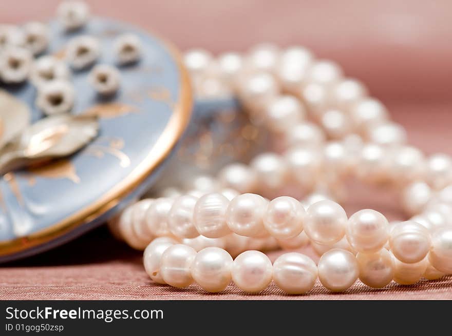 Beads of pearl on the pink background