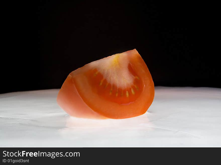 Red tomato on white ice. Studio shouting.