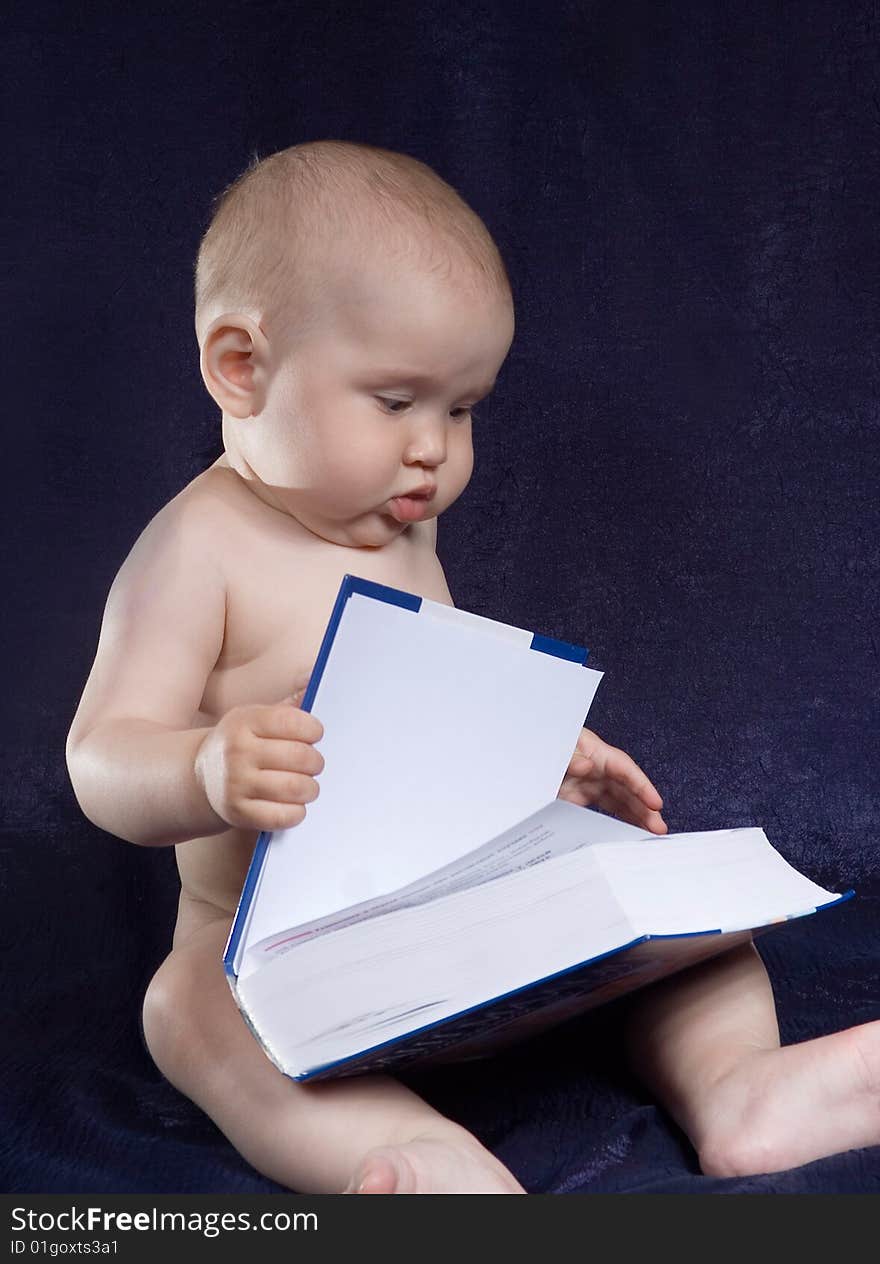 Child sits with book on turn blue background. Child sits with book on turn blue background