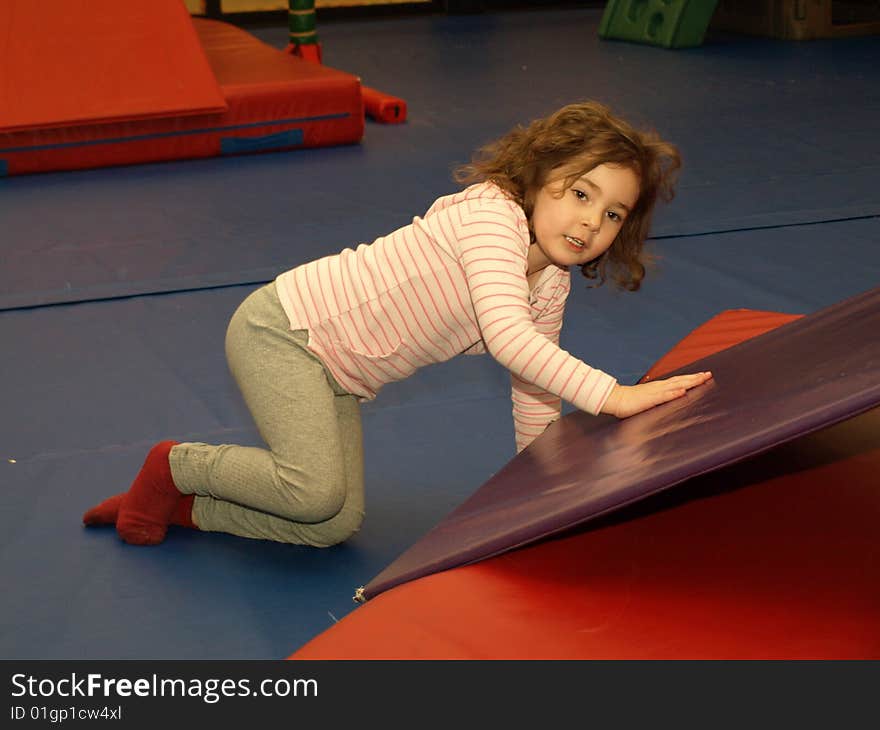 Young girl playing at an indoor playground having a good time. Young girl playing at an indoor playground having a good time.